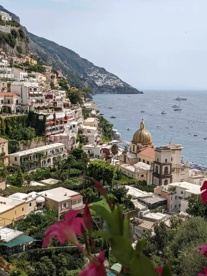 My view over Positano’s hillside buildings, church dome, and the Mediterranean Sea